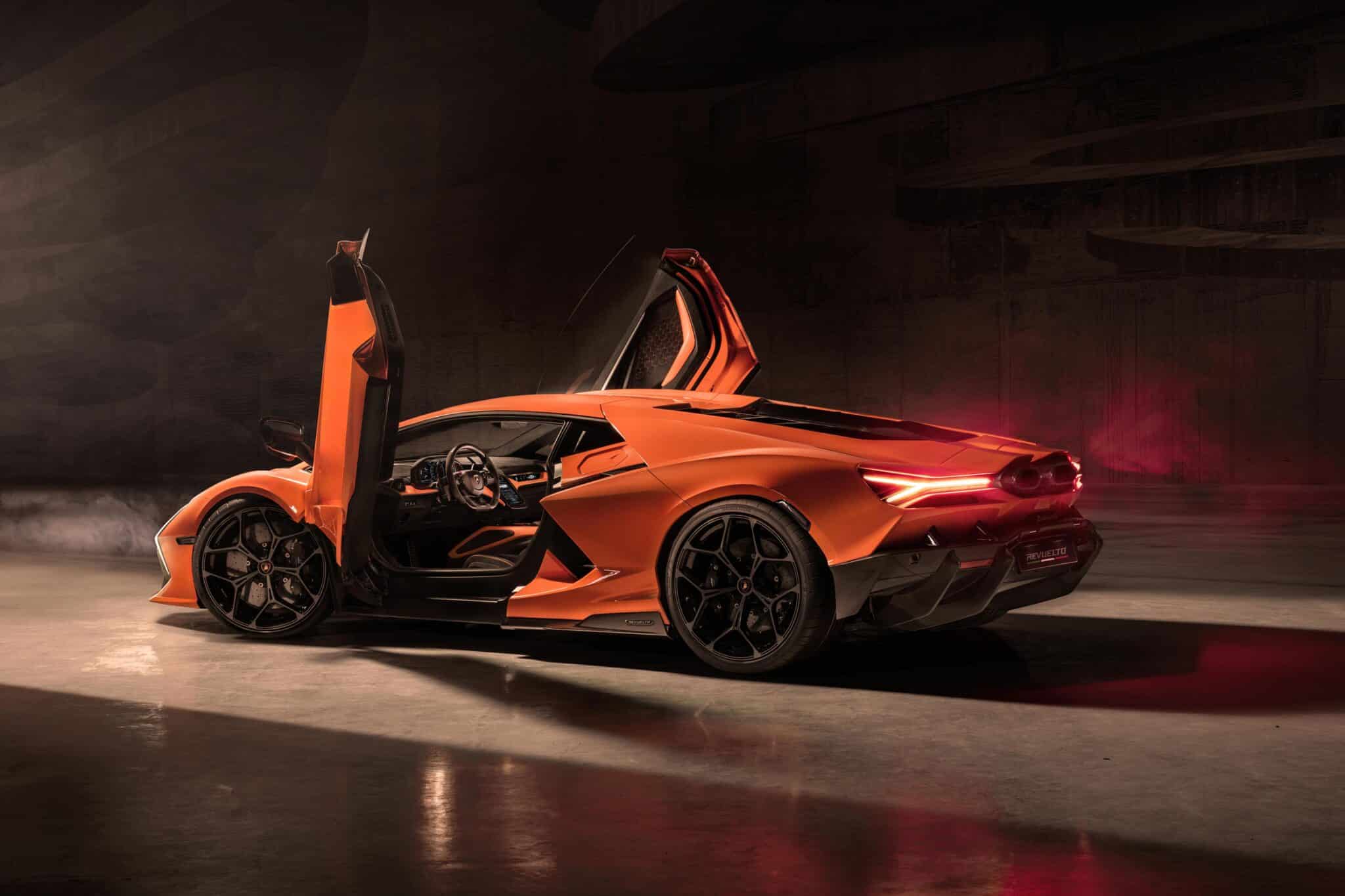 Düşük aydınlatmada, Lamborghini Revuelto spor otomobil, makas kapıları açıkken, şık tasarımını ve alaşım jantlarını sergilerken, aydınlatılmış kuyruk ışıkları zarafetini vurgular.