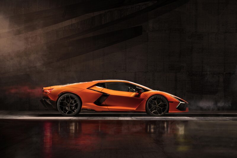 Bir Lamborghini Revuelto spor otomobili, loş aydınlatılmış alanda parlıyor, şık tasarımı yerdeki cilalı yansımada yakalandı ve fiyat hakkında tek bir kelime olmadan etkileyici özelliklerine işaret ediyor.